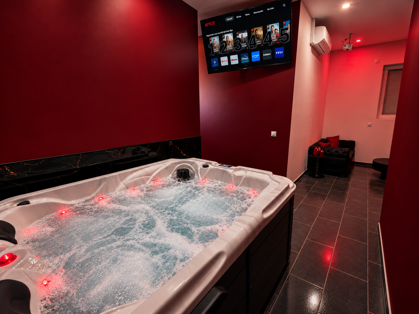 Vue complémentaire du jacuzzi privatif et de la télévision.